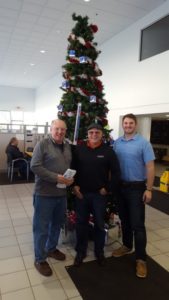 Jim, the Major, and Andy standing by the Christmas tree in the Frei Chevy showroom