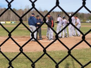 Team leaders meet at home plate before the Negaunee home baseball opening game