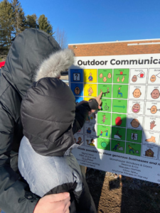 Child using Outdoor Communication board as tool for speaking