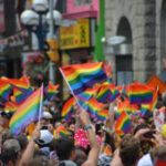 Crowd-waving-pride-flags-300×200