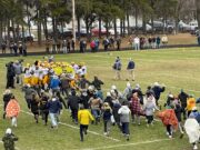 The Negaunee Student section rushes the field to celebrate with their team
