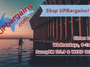U.P. Bargains Newsletter for 07-28-26 UPBargains.com advertisement asking shoppers to Shop UP Bargains and listen LIVE on Wednesdays from 9-11am on SunnyFM 101.9 & WFXD 103.3 on top of a photo of someone paddle boarding on Lake Superior next to the Ore Dock
