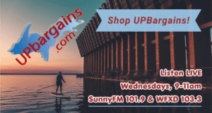 UPBargains.com advertisement asking shoppers to Shop UP Bargains and listen LIVE on Wednesdays from 9-11am on SunnyFM 101.9 & WFXD 103.3 on top of a photo of someone paddle boarding on Lake Superior next to the Ore Dock